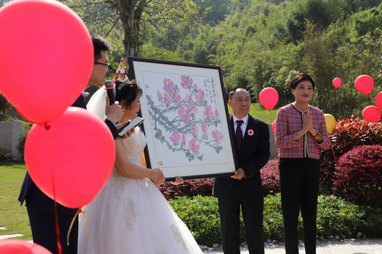 中国殡葬协会专家委员会主任伊华为这对新婚夫妇带来了一幅玉兰图作为礼物。白洁 摄