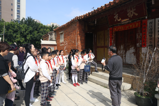 晋江市民俗专家粘良图在向学生和家长讲述五店市传统街区先贤庄用宾的故事