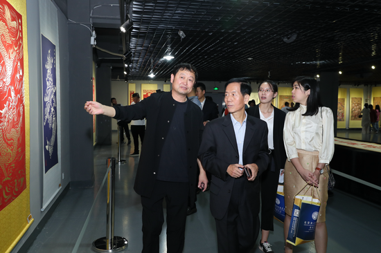 著名刻纸艺术家李艺发先生向中国文化信息协会会长黄河浪介绍刀刻画