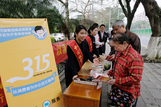 图为中国银行广西区分行工作人员向市民介绍金融消费相关知识