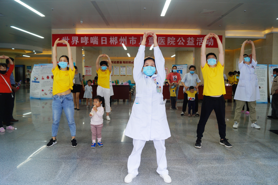 在义诊现场,工作人员们带着小朋友们跳呼吸康复操,小朋友们兴致高昂。
