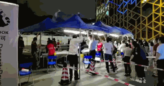 △ 面对突然来袭的狂风暴雨，社区工作人员当人肉支撑架避免帐篷坍塌，并紧急撤离医护人员和群众。
