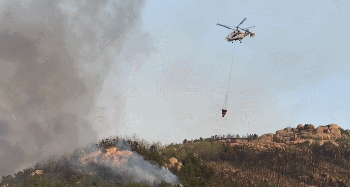 25日早上6时，现场有直升机一直在现场取水灭火。图据央视新闻