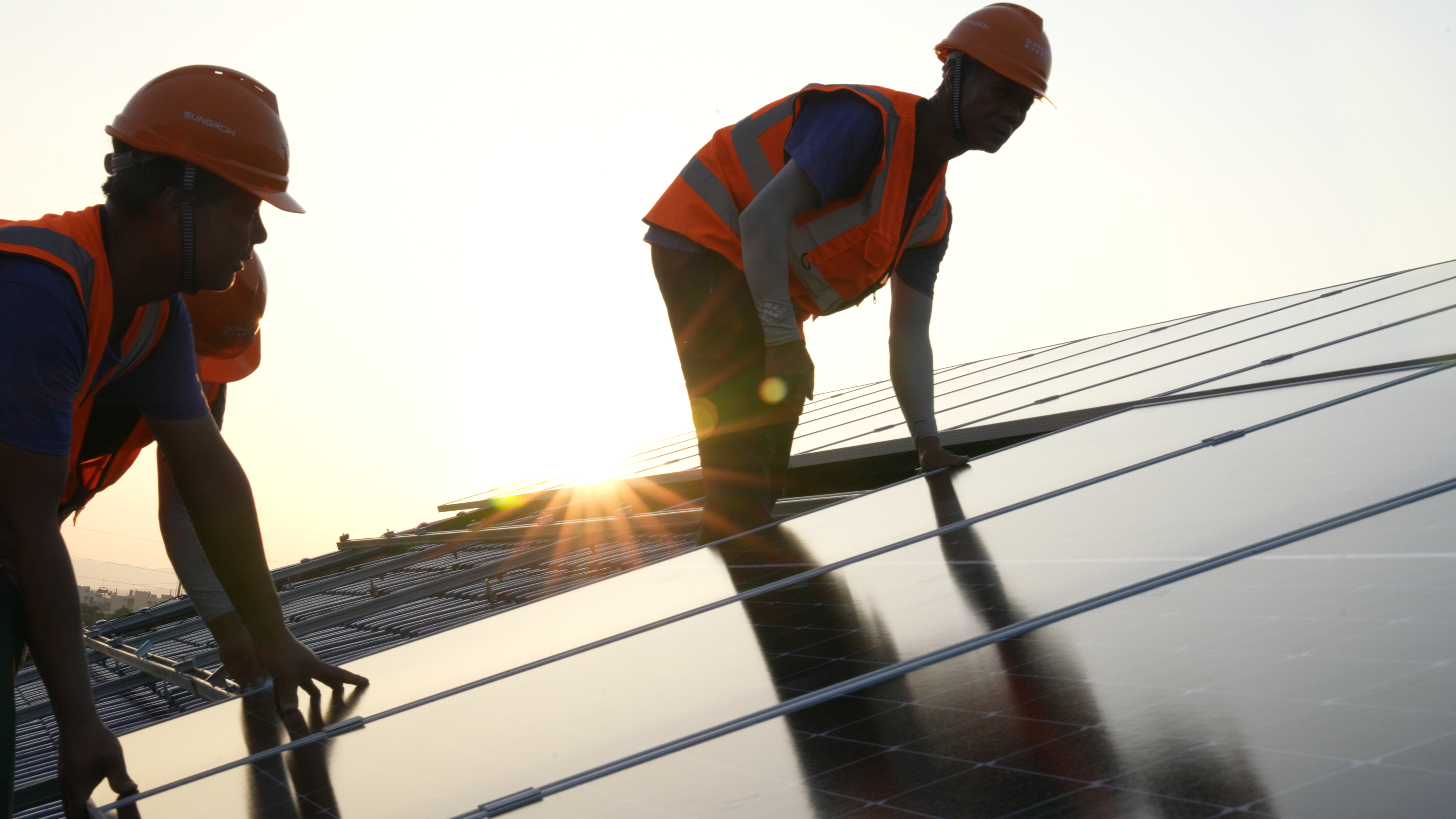 阳光新能源的工人正在给农户家屋顶安装家庭光伏