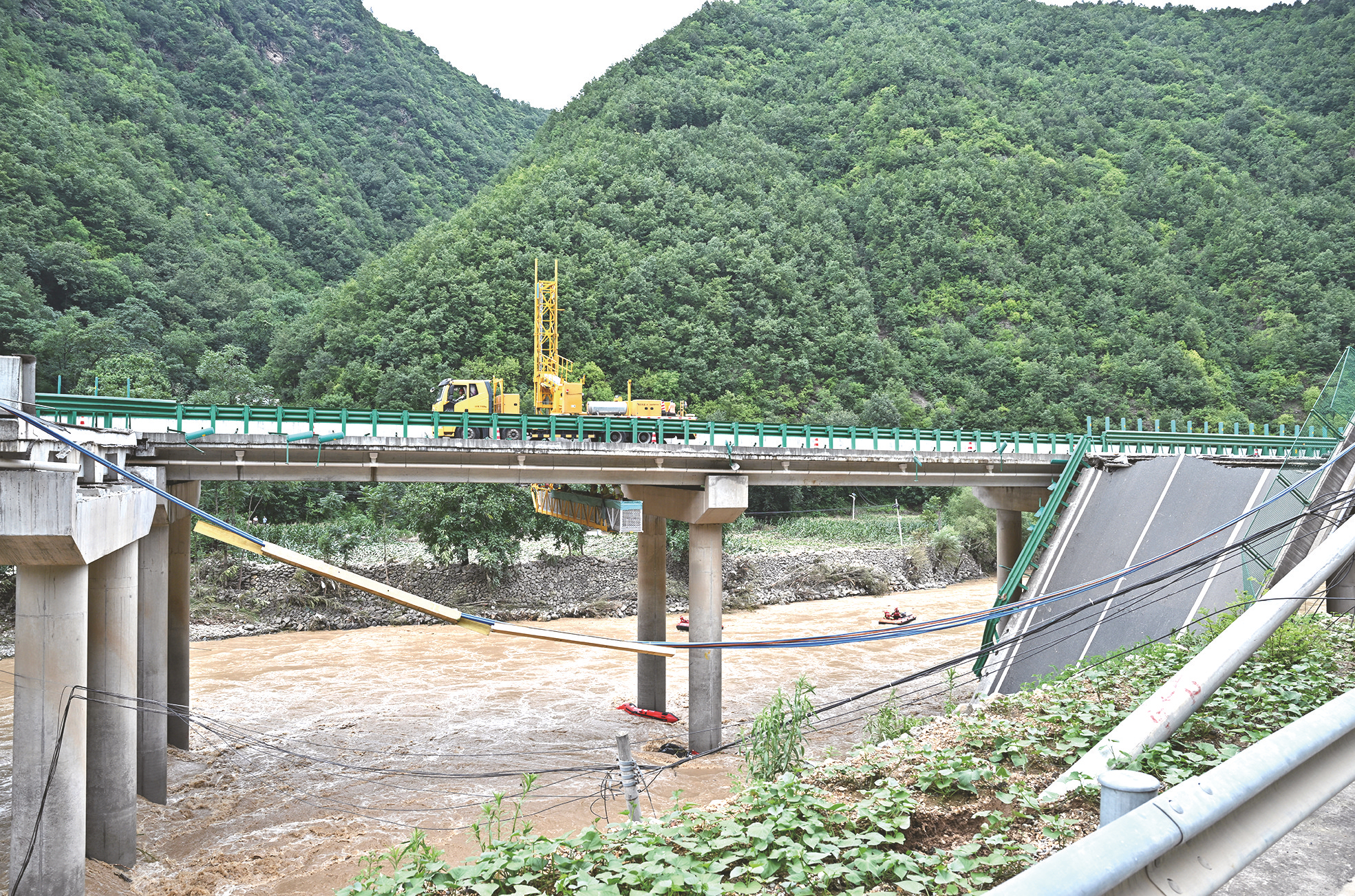     7月20日，在陕西柞水高速公路桥梁垮塌现场，救援人员正在进行搜救工作。新华社发