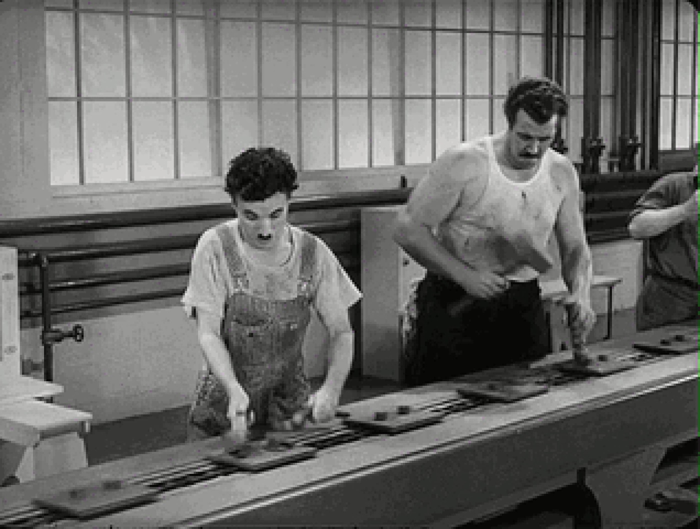 生产线上的工人正如卓别林在电影《摩登时代》中表演的一样,每一个